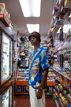 a man standing in front of a store filled with shelves and food items on display