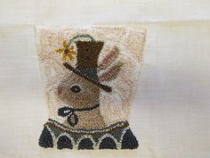 an embroidered image of a deer wearing a top hat