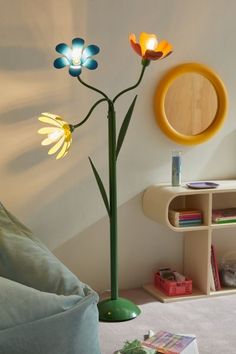 a living room with a flower lamp on the wall and a round mirror above it