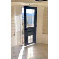 an empty room with a black door and tiled floor