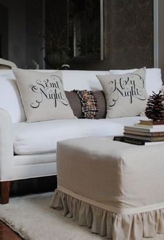 a living room with white couches and pillows on the floor next to a coffee table