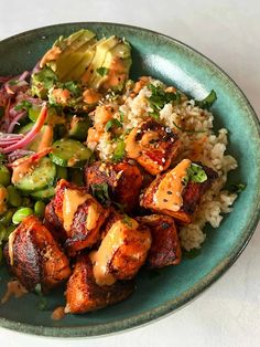 a blue plate topped with meat, rice and veggies