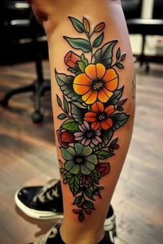 a woman's leg with flowers on it and an orange flower in the center