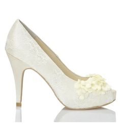 a woman's white high heel shoe with flowers on the toe and lace detailing