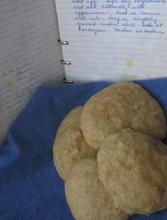 three round cookies sitting on top of a blue cloth next to a notepad and pen