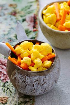 two bowls filled with food sitting on top of a table