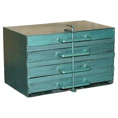 a green dresser with five drawers and metal handles