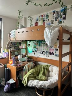 a bunk bed in a dorm room next to a desk with a laptop on it