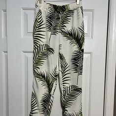 Elevate Your Wardrobe With These Stylish And Comfortable H&M Tropical Palm Leaf Pants. The Ivory, White, And Green Crepe Fabric Is Lightweight And Breathable, Making It Perfect For Any Season. The Pants Feature A Pull-On Closure And Elastic Waist For A Snug Fit, While The Tapered Leg Style And Flat Front Create A Flattering Silhouette. Ideal For Any Occasion, These Pants Are Suitable For Travel, Parties, Casual Wear, Work, Or Formal Events. The Colorful And Preppy Theme Adds A Touch Of Modern An H&m Summer Bottoms For Vacation, H&m Straight Pants For Summer, H&m Summer Straight Pants, H&m Bottoms For Spring Vacation, H&m Straight Summer Pants, Chic H&m Bottoms For Vacation, Casual White H&m Bottoms, H&m Casual White Pants, Casual White H&m Pants