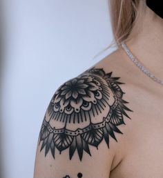 a woman's shoulder with an intricate tattoo design on her left arm and chest