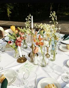 the table is set with flowers and candles