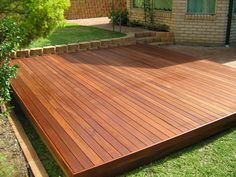 a wooden deck in front of a brick house