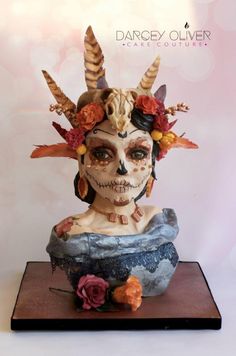 a statue of a woman with horns and flowers on her head