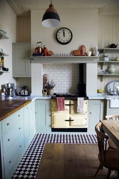 an old fashioned stove in a kitchen with wooden table and chairs