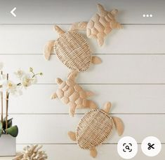 three sea turtle wall hangings on the wall next to a vase with flowers in it