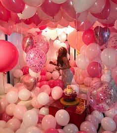 an instagram with balloons and pinks on the wall, some people are looking at them