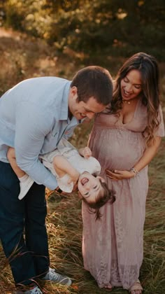 a man and woman holding a baby in their arms