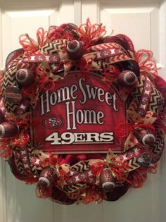 a football wreath with the words home sweet home, and some baseballs on it