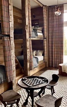 a living room filled with furniture and a chess board on top of a table in front of a window