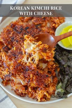 korean kimchi rice with cheese is on a white plate and has a wooden spoon in it