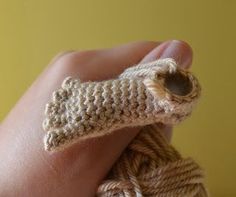 a hand holding a crocheted object in it's left palm and fingers