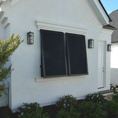 a white house with black shutters on the windows