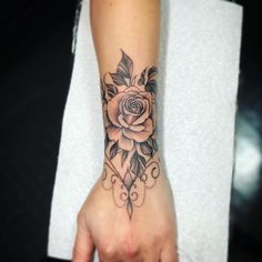 a woman's arm with a rose tattoo on the left side of her hand