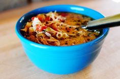 a blue bowl filled with soup on top of a wooden table