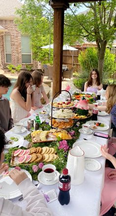 a group of people sitting around a table covered in food