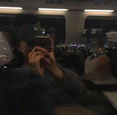 a man taking a photo on his cell phone while riding the subway train at night