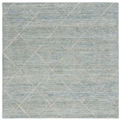 an area rug with diamond shapes on the top and bottom, in light blue tones