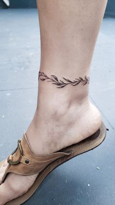 a woman's foot with a small tattoo on the left side of her ankle