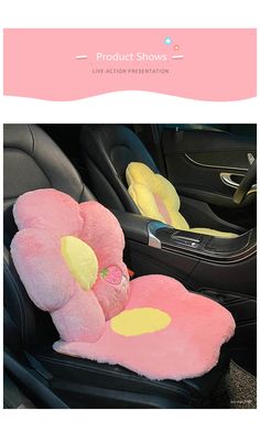 a pink teddy bear sitting in the back seat of a car