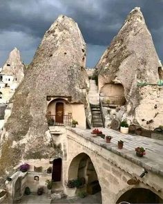 some very pretty buildings with big rocks in the back ground and stairs leading up to them