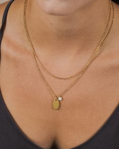 Add dainty details to your favorite looks with this layered piece! It features a smooth disk charm and a glam opal charm. This necklace is available in gold and silver tones. Materials: 14K gold or rhodium plated brass, created opal Features: Measures 16-18" with 2" extender, 0.35" & 0.75" pendants, 5mm opal stone, 2mm chain, Lead & Nickel free, lobster clasp Gold Layered Necklace With Pearl Pendant, Charm Necklace With Delicate Chain And Round Pendant, Delicate Round Charm Necklaces For Layering, Dainty Gold Layered Charm Necklaces, Gold Charm Necklace With Pearl For Layering, Gold Pearl Charm Necklace For Layering, Tarnish Resistant Round Pendant Charm Necklaces For Layering, Tarnish Resistant Round Pendant Charm Necklaces, Tarnish-resistant Round Pendant Charm Necklace For Layering