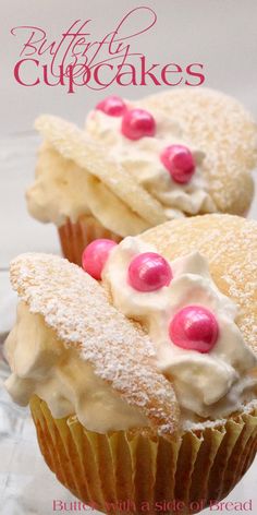 two cupcakes with white frosting and pink candies on top are shown