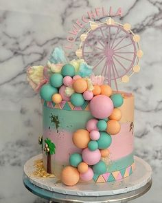 there is a cake decorated with balloons and a ferris wheel on the top of it