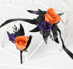 two orange and purple flowers with black ribbons on top of each flower headbands