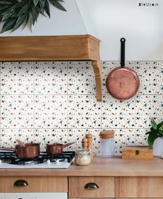 a kitchen counter with pots and pans on it next to a stove top oven