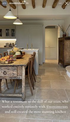 a kitchen with an old table and chairs in the center is decorated with wood beams