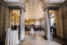 a bride and groom are standing in the middle of a hall