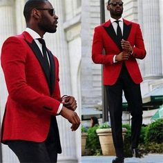 a man in a red suit and black tie standing next to another man wearing a white shirt