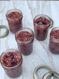 several jars filled with jam sitting on top of a table next to a pair of handcuffs