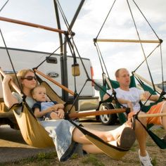 two women and a baby are sitting in hammocks