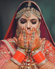 a woman in red and gold holding her hands to her face with both hands on her face