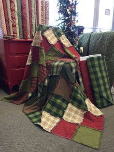 a pile of blankets sitting on top of a bed next to a christmas tree