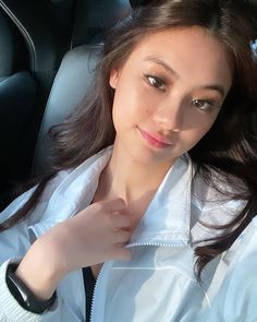 a woman sitting in the back seat of a car with her hand on her shoulder