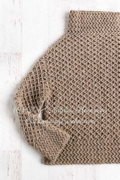 a close up of a knitted sweater on a white wooden surface with the words,