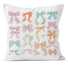 a white pillow with bows on the front and back, all in pastel colors