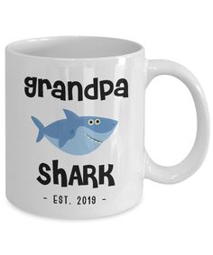 a white coffee mug with an image of a shark and the words grandpa shark on it